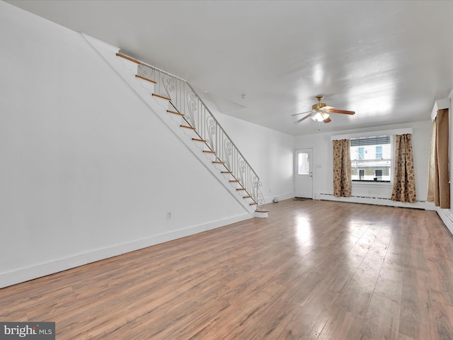 unfurnished living room with hardwood / wood-style flooring, ceiling fan, and a baseboard heating unit