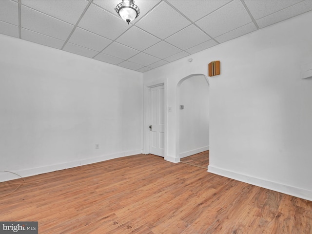 empty room with a paneled ceiling and wood-type flooring