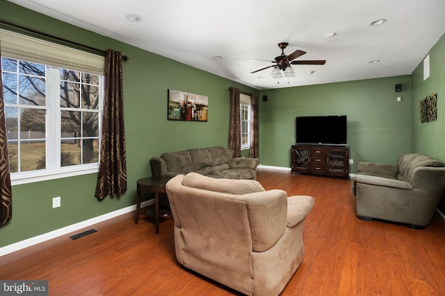 living area with recessed lighting, wood finished floors, a ceiling fan, visible vents, and baseboards