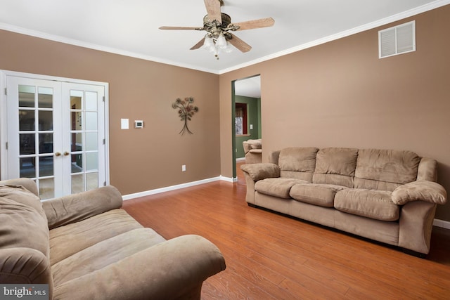 living room featuring french doors, visible vents, ornamental molding, wood finished floors, and baseboards