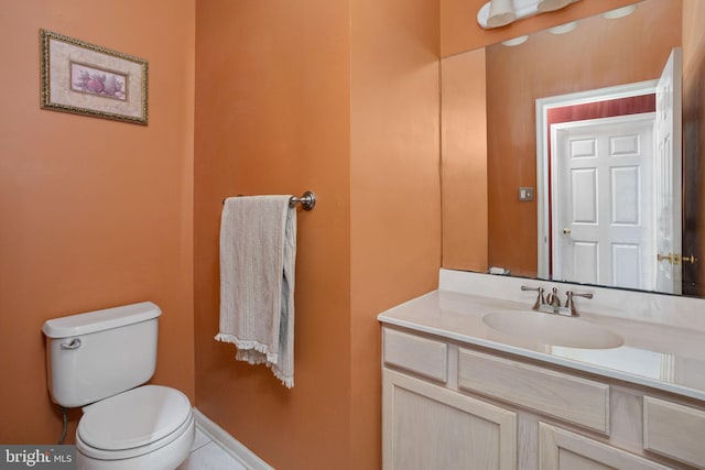 bathroom with toilet, baseboards, and vanity