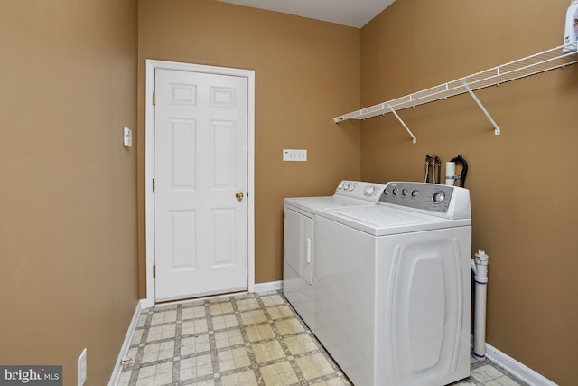 laundry room with washer and dryer, laundry area, baseboards, and light floors