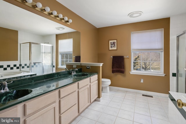 bathroom with a stall shower, plenty of natural light, visible vents, and a sink