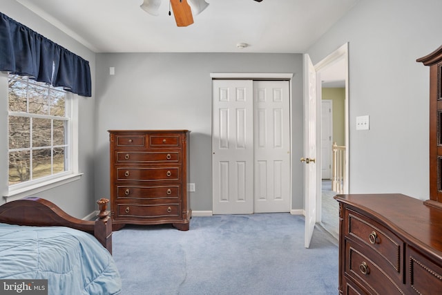 bedroom featuring carpet floors, a closet, baseboards, and a ceiling fan