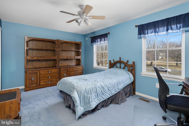 carpeted bedroom featuring ceiling fan, visible vents, and baseboards