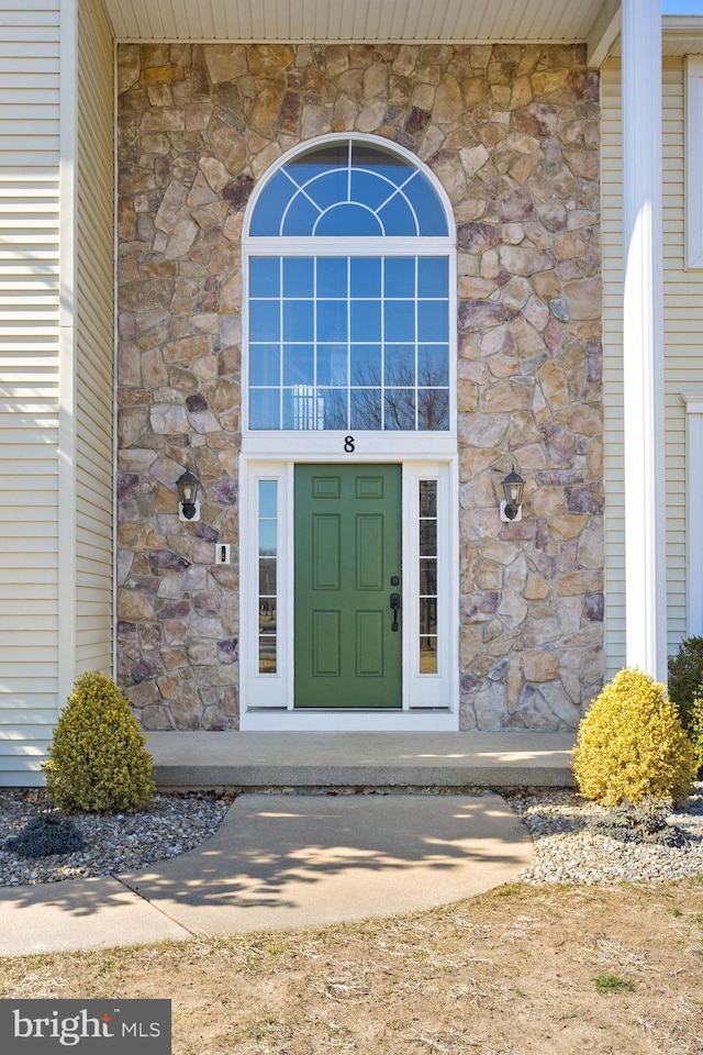 property entrance featuring stone siding