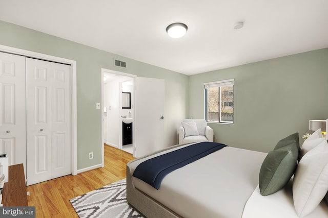 bedroom featuring a closet, light hardwood / wood-style flooring, and ensuite bath