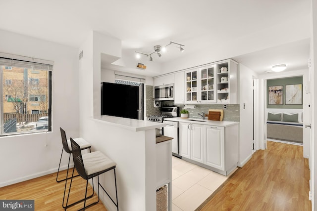 kitchen with white cabinets, plenty of natural light, tasteful backsplash, refrigerator, and a kitchen bar