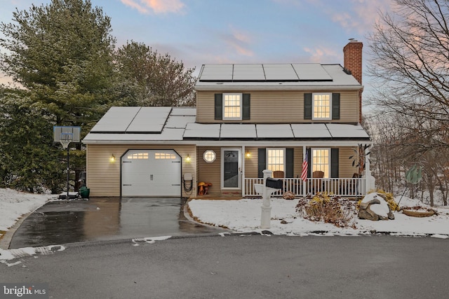 view of front facade with solar panels, a porch, and a garage