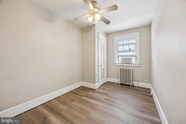 spare room featuring ceiling fan, radiator, and light hardwood / wood-style floors