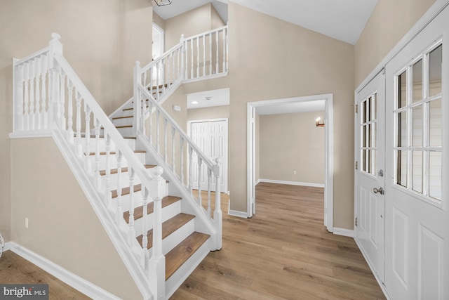 stairway with a high ceiling and wood-type flooring