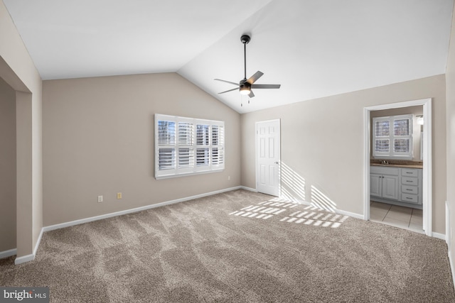 unfurnished room featuring lofted ceiling, ceiling fan, light carpet, and sink