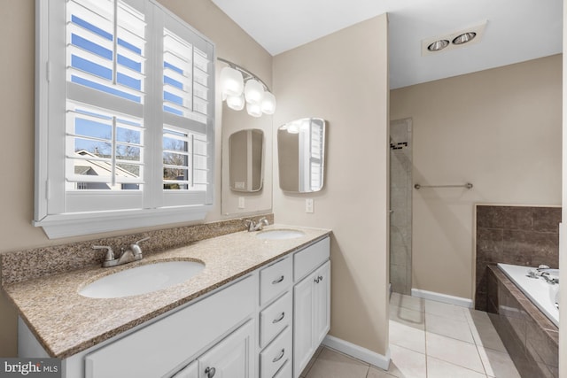 bathroom with vanity, tile patterned floors, and a relaxing tiled tub