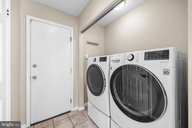 washroom featuring light tile patterned flooring and washing machine and clothes dryer