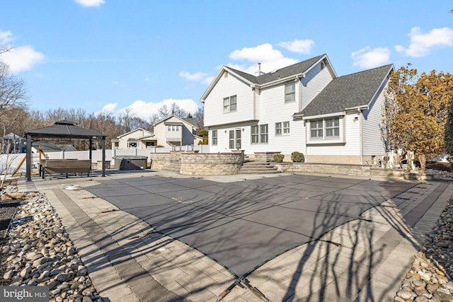 back of property featuring a gazebo, a patio area, and a jacuzzi