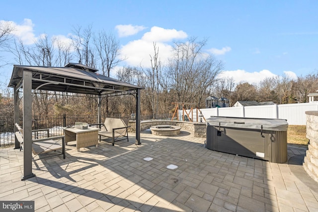 view of patio featuring a gazebo, a playground, a hot tub, and an outdoor hangout area