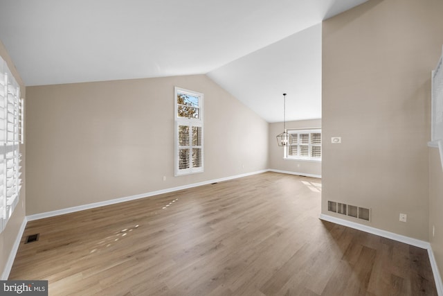 interior space with lofted ceiling, a chandelier, and light wood-type flooring