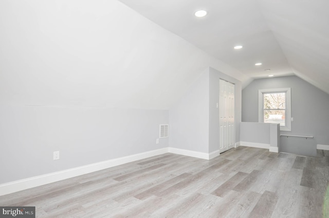 bonus room featuring lofted ceiling and light wood-type flooring