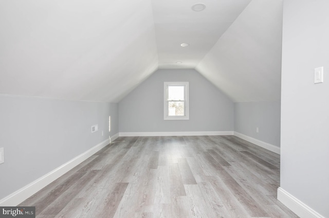 additional living space featuring light hardwood / wood-style flooring and vaulted ceiling