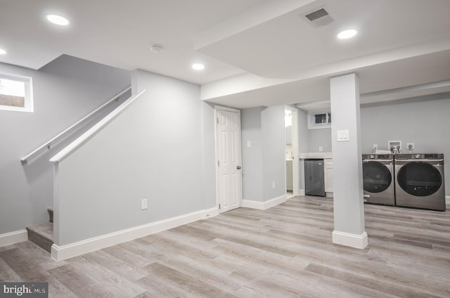 basement featuring light wood-type flooring and washing machine and clothes dryer