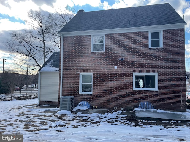 snow covered property with cooling unit