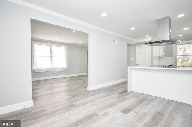 kitchen featuring island exhaust hood, white cabinetry, crown molding, and light hardwood / wood-style flooring