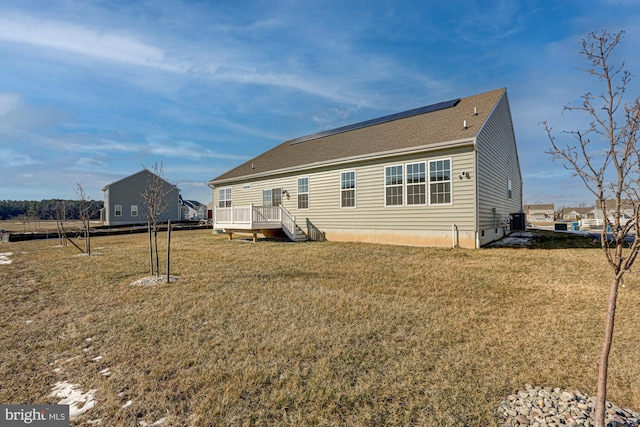 rear view of house featuring a deck, a yard, and central AC unit