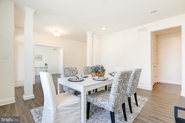 dining area featuring decorative columns and dark hardwood / wood-style floors