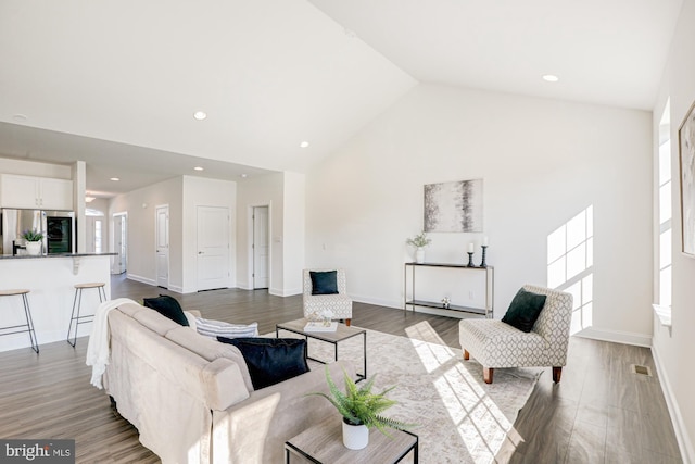 living room with vaulted ceiling, plenty of natural light, and light hardwood / wood-style flooring