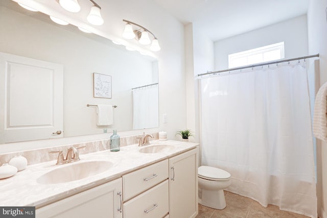 bathroom featuring vanity, tile patterned flooring, toilet, and walk in shower