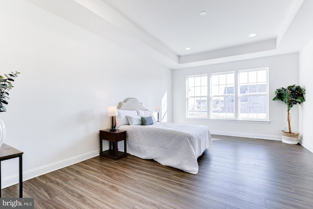 bedroom featuring a tray ceiling and dark hardwood / wood-style floors