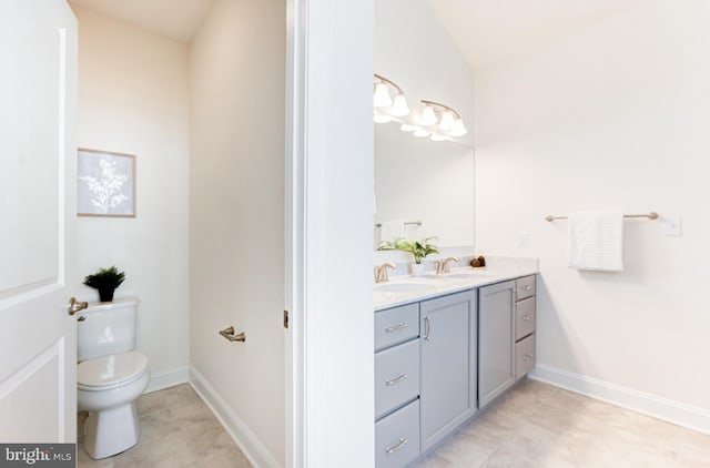 bathroom with toilet, vaulted ceiling, and vanity