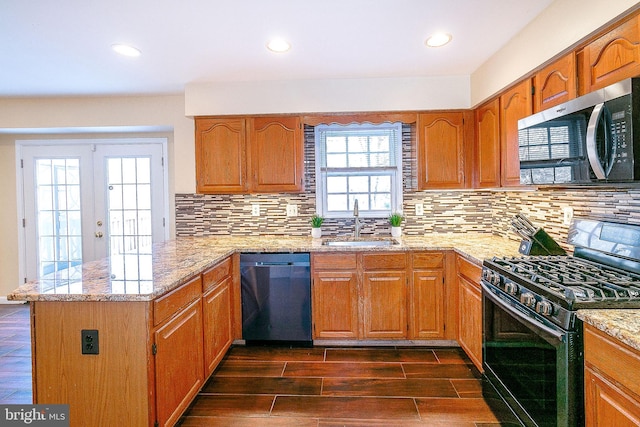 kitchen featuring stainless steel appliances, tasteful backsplash, sink, and kitchen peninsula