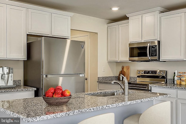 kitchen featuring appliances with stainless steel finishes, white cabinetry, and sink