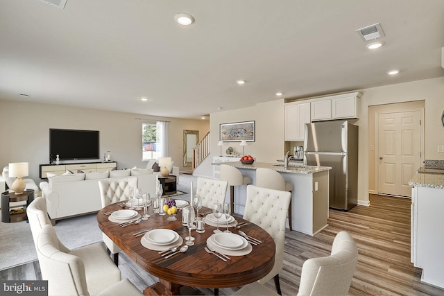 dining area with sink and light hardwood / wood-style floors