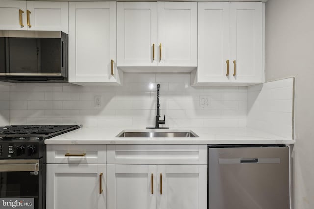 kitchen featuring sink, white cabinets, decorative backsplash, and stainless steel appliances