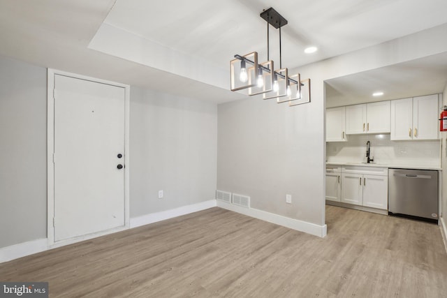 unfurnished dining area featuring sink and light hardwood / wood-style floors