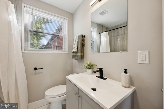 bathroom featuring vanity, toilet, and a shower with curtain