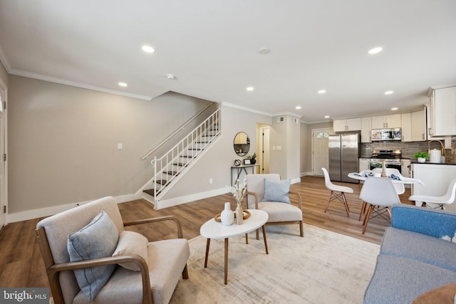 living room with light hardwood / wood-style flooring and ornamental molding