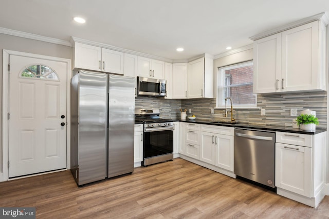 kitchen featuring sink, white cabinets, tasteful backsplash, and appliances with stainless steel finishes