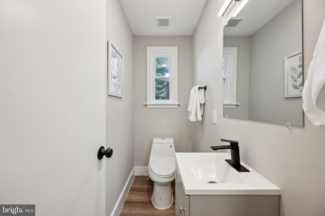 bathroom with vanity, toilet, and wood-type flooring