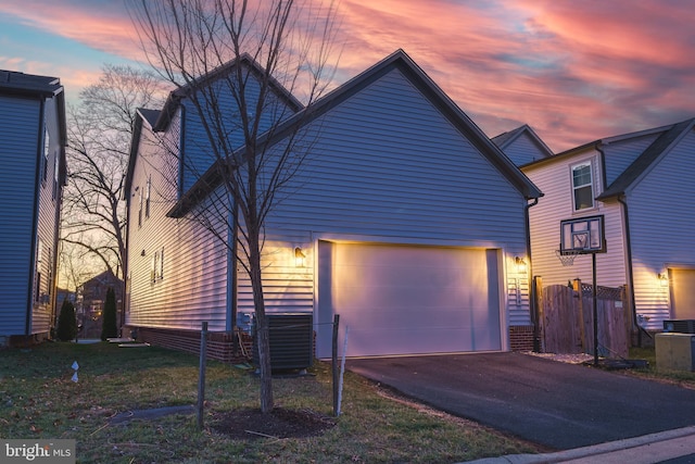 property exterior at dusk featuring a garage and central AC unit