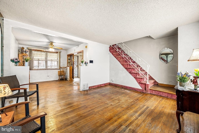 interior space featuring ceiling fan, a textured ceiling, and wood-type flooring