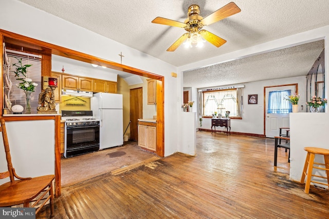 kitchen with light hardwood / wood-style floors, ceiling fan, white fridge, and gas range oven