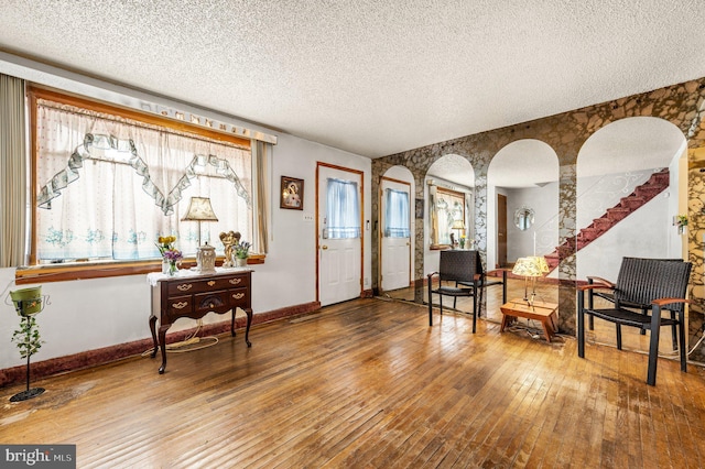 foyer entrance with hardwood / wood-style flooring, a textured ceiling, and a healthy amount of sunlight