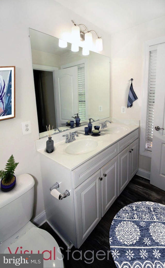 bathroom featuring toilet, wood-type flooring, and vanity