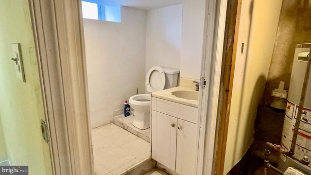 bathroom with vanity, gas water heater, and toilet