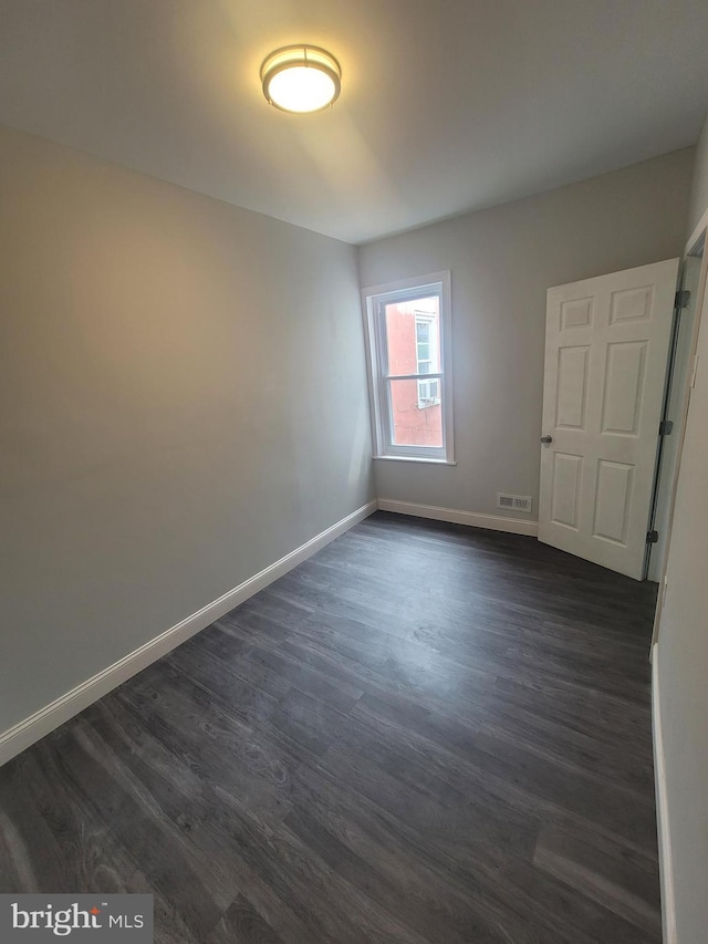 spare room with dark hardwood / wood-style flooring