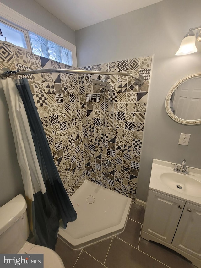 bathroom with tile patterned flooring, vanity, toilet, and curtained shower