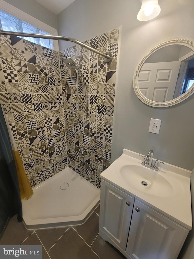 bathroom featuring a tile shower, tile patterned flooring, and vanity